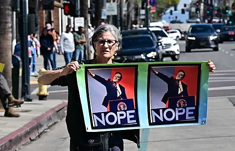 People participate in a "Tesla Takedown" protest against Elon Musk outside a Tesla dealership in Pasadena, California, 8 March 2025. US President Donald Trump's senior advisor Elon Musk is leading the so-called Department of Government Efficiency (DOGE), which has cut thousands of government jobs and upended agencies, prompting numerous court challenges.