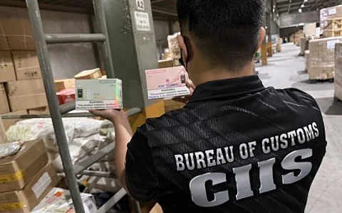 A member of the Bureau of Customs-Customs Intelligence and Investigation Service inspect the illegal vapes and other counterfeit items during a raid conducted at a warehouse in Malabon City.
