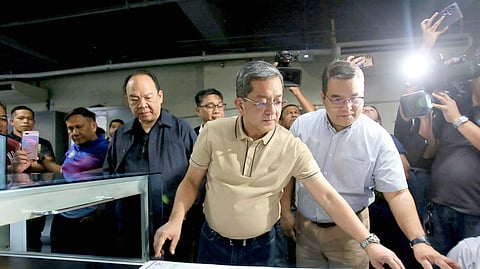 COMELEC Chairman George Erwin Garcia and Commissioner Ernesto Maceda roll up their sleeves, overseeing the final touches on 68,542,564 official ballots at the NPO main office in Quezon City.
