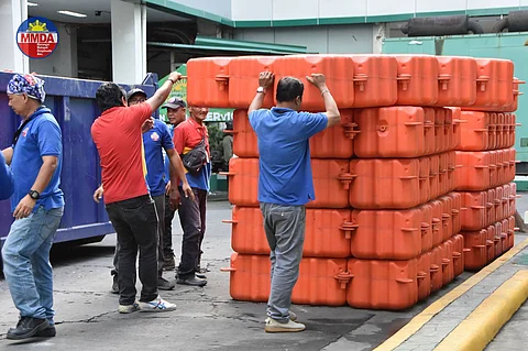 Workers from the Metropolitan Manila Development Authority unload the trash traps that are turned over to the local government of Parañaque.