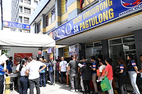 A RESPONSIBLE GAMING banner (inset) is prominently displayed in front of the PCSO Main Office Conservatory Building along Shaw Boulevard in Mandaluyong City.