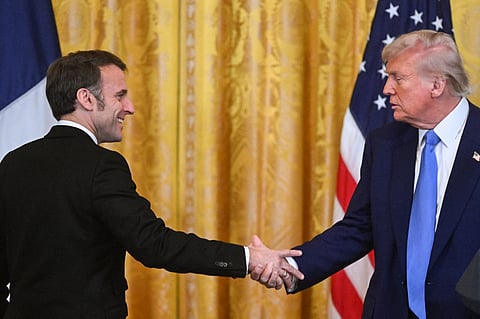 US President Donald Trump and French President Emmanuel Macron shake hands at the end of a joint press conference in the East Room to the White House in Washington, DC, on 24 February 2025.