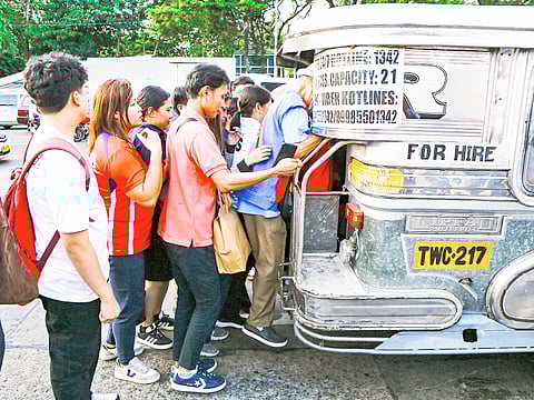 Passengers queue at a jeepney terminal in Quezon City as some drivers did not participate in the first day of the transport strike launched by Manibela on Monday.
