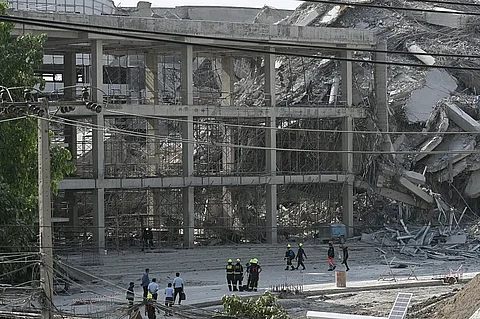 Rescue workers look at the debris of a construction site after a building collapsed in Bangkok on March 28, 2025, following an earthquake. A powerful earthquake rocked central Myanmar on March 28, buckling roads in capital Naypyidaw, damaging buildings and forcing people to flee into the streets in neighbouring