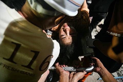 Phyu Lay Khaing is rescued from the rubble of the collapsed Sky Villa Condominium apartment building before being transported to the hospital in Mandalay on 29 March 2025, a day after an earthquake struck central Myanmar. Rescuers pulled a woman alive from the wreckage of a collapsed apartment building in Mandalay on 29 March, AFP journalists saw, 30 hours after a devastating quake hit Myanmar.