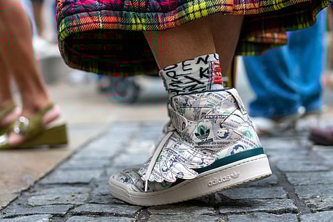 NEW YORK: A guest is seen wearing a pair of Jeremy Scott X Forum Wings 1.0 Money sneakers at the Moschino by Jeremy Scott Spring Summer 2022 fashion show during New York Fashion Week at Bryant Park on 09 September 2021 in New York City.