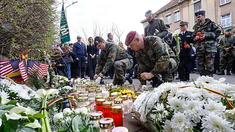 German and other NATO soldiers lay flowers and light candles outside the US Embassy in Vilnius, Lithuania, on 1 April 2025, to honor the four US soldiers who died during a military drill at the Pabrade training ground. All four soldiers, who had been missing since last week, have now been confirmed dead after rescuers recovered their armored vehicle from a swamp.