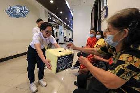 Volunteers lead prayers (right) and collect donations from patients at the Tzu Chi Eye Center in Sta. Mesa, Manila.