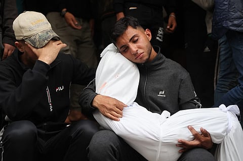 A Palestinian man mourns as he holds the shrouded body of a relative, killed in a reported Israeli strike, ahead of their funeral at the Ahli Arab Hospital, also known as the Maamadani (Baptist) Hospital, in Gaza City on 6 April 2025. Israel's military resumed its offensive in Gaza on 18 March, and since then, more than 1,330 people have been killed in the territory, according to the Hamas-run territory's health ministry.