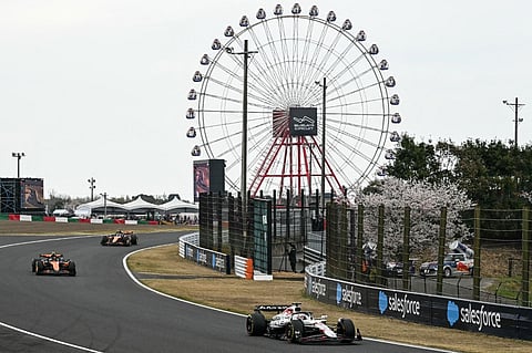 Red Bull Racing's Dutch driver Max Verstappen (R) leads in the first lap during the Formula One Japanese Grand Prix at the Suzuka circuit in Suzuka, Mie prefecture, Japan on 6 April 2025.