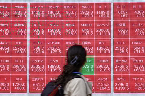A woman looks at an electronic board showing the Nikkei 225 index on the Tokyo Stock Exchange in Tokyo on 8 April 2025. Tokyo's Nikkei index jumped nearly six percent in early trade on 8 April 8 after plunging an eye-watering 7.8 percent the previous day, as US tariffs fuel market volatility.
