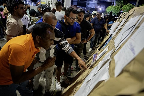 People check on the lists of victims from the Jet Set nightclub following the collapse of its roof in Santo Domingo on April 8, 2025. Rescuers raced to find survivors on April 8, 2025, among the rubble of a Dominican Republic nightclub where at least 79 people, including a former Major League Baseball star, were killed when the roof collapsed.