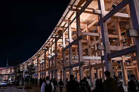 Visitors walk past the "Grand Ring", made of wood, at the end of a media preview day for the 2025 Osaka Expo in Osaka on 9 April 2025, four days before the event opens to the public for six months.