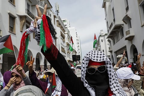 A demonstrator flashes the victory sign during a national march in support of Palestinians and against Morocco's normalisation of ties with Israel, in the capital Rabat on 6 April 2025.
