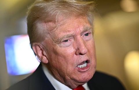 US President Donald Trump speaks to reporters aboard Air Force One, during the flight from Palm Beach to Joint Base Andrews, as he returns to the White House in Washington, DC, 13 April 2025.