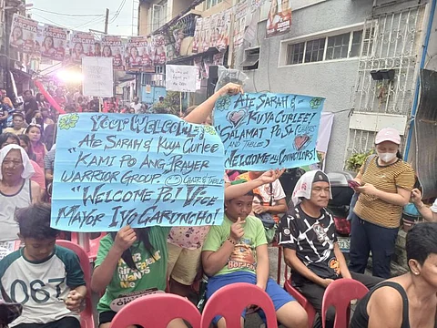 PASIG City voters await the arrival of mayoral candidate Sarah Discaya with their placards making clear what their sentiments are.