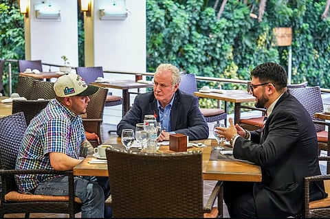 US Senator Chris Van Hollen meets with Kilmar Abrego Garcia and another official at a hotel restaurant in San Salvador, El Salvador, on 17 April 2025. The group is seated at a table for a discussion following the controversial deportation.