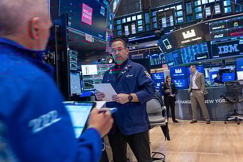 Traders work on the floor of the New York Stock Exchange (NYSE) surrounded by monitors displaying financial data and stock tickers, as concerns about a potential U.S. recession mount in April 2025.