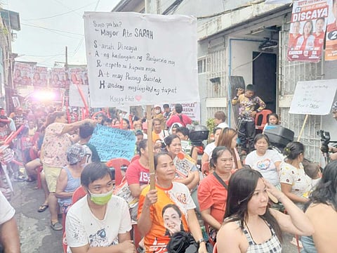 Their choice A woman raises a placard for Pasig mayoral hopeful Ate Sarah Discaya at a public caucus in Barangay Ugong.