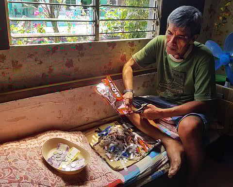 WILLIE Mandanas cuts cleaned plastic waste into small strips before selling it for recycling.