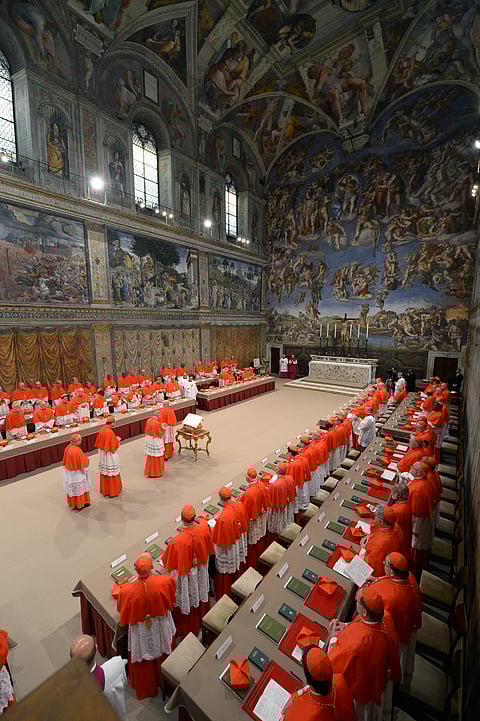 (FILES) This handout picture released by the Press office shows cardinals queuing in the Sistine Chapel to swear on the Bible to never reveal the secrets of their deliberations before the start of the conclave at the Vatican on 12 March 2013. Pope Francis died on 21 April 2025 aged 88, a day after making a much hoped-for appearance at Saint Peter's Square on Easter Sunday, the Vatican said in a statement.