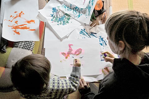 TWENTY-ONE-MONTH-OLD artist ‘Thumbelina’ (left) uses a brush to paint alongside her mother at the family’s home in Tokyo.