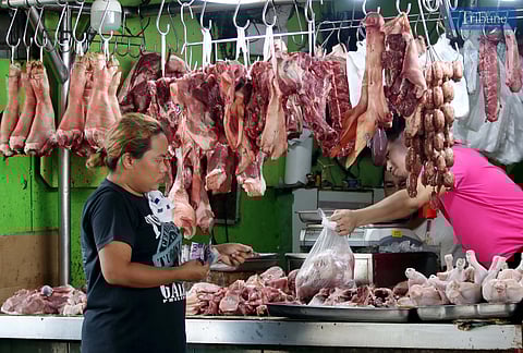 A pork meat vendor tends to customers at Balintawak Market on Wednesday, 23 April 2025. The Department of Agriculture’s Food Terminal Inc. (FTI) has called on more hog farms to join a pilot program aimed at lowering pork prices and curbing profiteering in the supply chain.