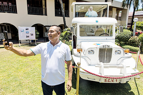 A CATHOLIC devotee takes pictures with the ‘Pope Jeep,’ which is parked at the Sanctuario de San Antonio Parish on McKinley Road in Makati City on Friday. This vehicle was used by Pope Francis during his visit to the Philippines in 2015, and it will remain parked outside the church until 4 May.