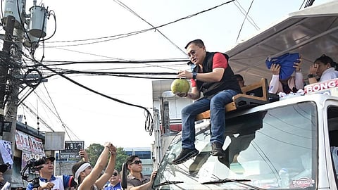 VENDOR Christopher Loyd Javier offers fresh buko and a towel to Senator Bong Go during a motorcade in Cainta, Rizal, a simple gesture of gratitude from a scholar of the senator’s educational assistance program.