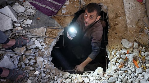 A man searches for victims or survivors amid the rubble of a house hit in a strike on Gaza City