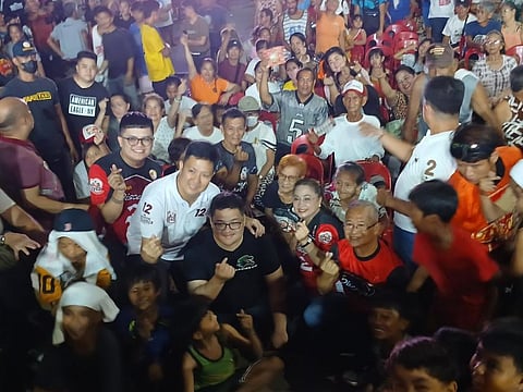 PASIG mayoral aspirant Sarah Discaya, joined by her son Gerrard (in a black shirt and eyeglasses), poses for a group photo with supporters and local residents during a caucus in Barangay Pineda on Friday evening.