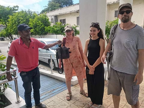 The taxi driver identified as Melchor Panilon (left) returns the belongings left by a foreigner who rode his cab in Cebu City.