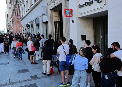 People queue outside a building in Madrid, Spain, following a widespread power outage that disrupted services across the Iberian Peninsula on 28 April 2025.