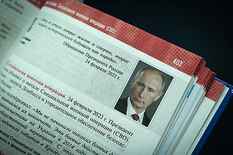 A page from a Russian high school history textbook shows a portrait of President Vladimir Putin alongside text referencing the "special military operation" in Ukraine and the annexation of Crimea, presented in Moscow on 7 August 2023.