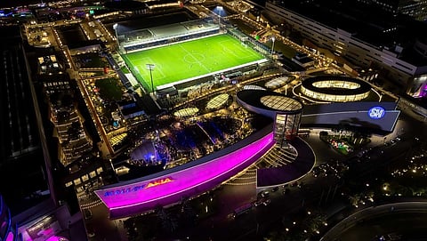 Aerial view of SM Mall of Asia’s football field and activity area, lit up at night during a summer sports event.
