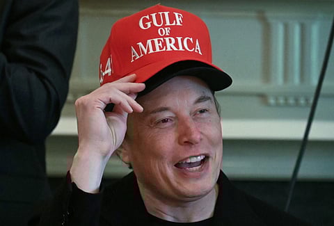 Elon Musk, wearing two hats, speaks during a cabinet meeting in the Cabinet Room of the White House in Washington, DC, on 30 April 2025.