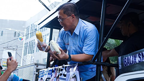 Senator Christopher ‘Bong’ Go receives sweet corns from Valenzuela residents during a campaign sortie on Tuesday.