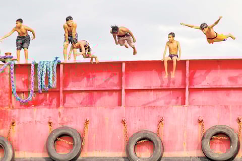 In the heart of Tondo, Manila, children from Baseco find a daring way to escape the scorching heat — by leaping off a barge moored at the seawall.