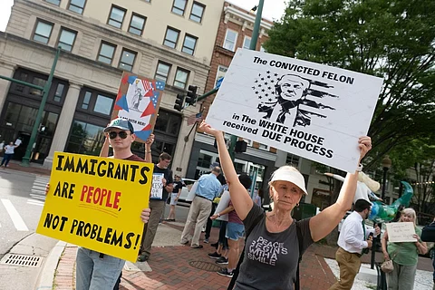 Residents of Norfolk, Virginia, rally in front of the city's federal building holding pro-immigrant signs, protesting against the Trump administration's deportations.