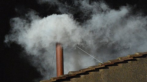 White smoke billows from the chimney atop the Sistine Chapel roof, signaling the successful election of a new pope during the 2013 conclave at the Vatican.
