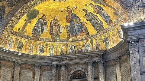 Mosaic of Christ enthroned with saints and apostles in the apse of the Papal Basilica of Saint Paul Outside the Walls in Rome, featuring rich gold background and intricate detailing.