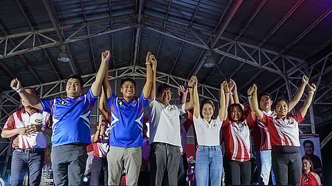 Cavite gubernatorial candidate Abeng Remulla (center, in white) raises hands with former Senator Kiko Pangilinan and local candidates during a campaign rally in Magallanes, Cavite on 9 May 2025, showing united support for Pangilinan’s Senate bid.