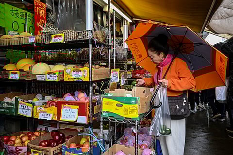 A person shops at a market in Chinatown on April 11, 2025 in New York. China said Friday it would raise its tariffs on US goods to 125 percent in a further escalation of a trade war that threatens to bring exports to a halt between the world's two biggest economies. Beijing's retaliation sparked fresh market volatility, with stocks seesawing, gold prices surging and US government bonds under pressure.
