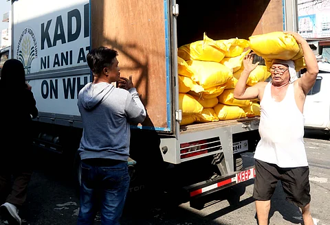 WORKERS from Kadiwa on Wheels unload sacks of rice to deliver at the government’s rice-for-all Kadiwa ng Pangulo Kiosk program at the Kamuning Public Market in Quezon City.