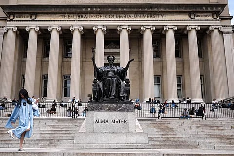 Flanking a famous Alma Mater statue, students sit on the steps of the Low Memorial Library at New York's Columbia University on April 14, 2025