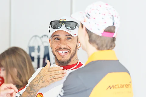 Lewis Hamilton of Great Britain and Scuderia Ferrari talks with Oscar Piastri of Australia and McLaren prior to the F1 Grand Prix of Miami.