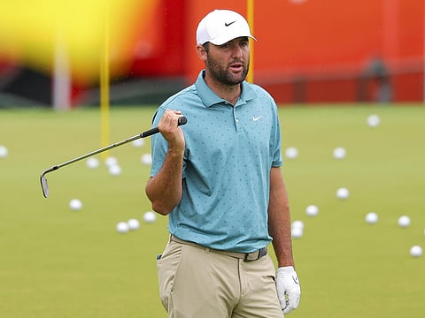 World number one Scottie Scheffler of the United States warms up at the driving range on the rainy first practice day for the 107th PGA Championship at Quail Hollow