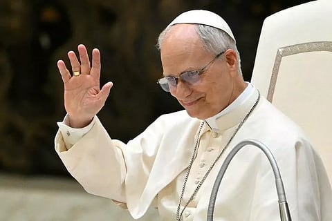 Pope Leo XIV smiles and waves while addressing members of the media during an audience at Paul VI Hall in the Vatican on 12 May 2025.