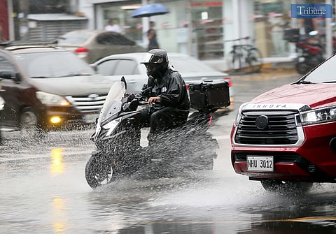 (FILES) Motorcycle riders pass EDSA in Quezon City wearing raincoats for protection during a thunderstorm on Wednesday, 14 May 2025.