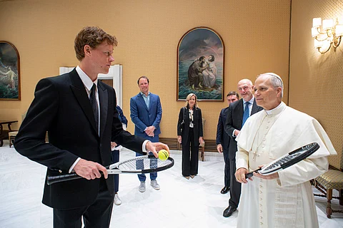 JANNIK Sinner (left) hands a racket to Pope Leo XIV ahead of his Italian Open quarterfinal clash with Casper Ruud.